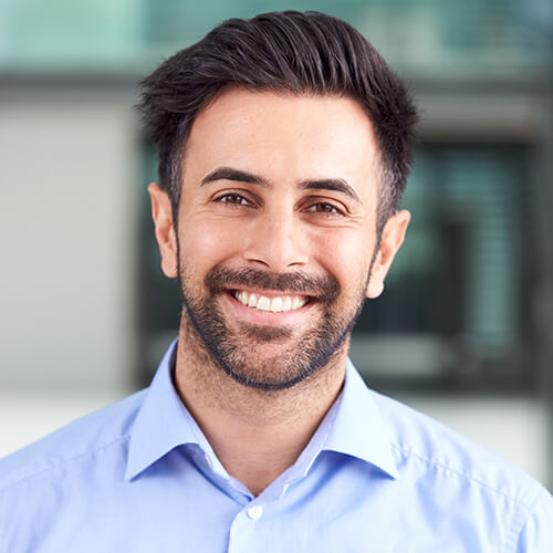portrait-of-smiling-businessman-standing-in-lobby-3QPCMXE.jpg
